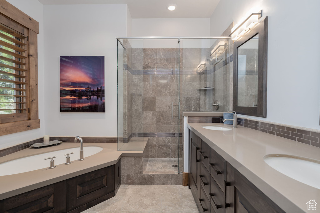 Bathroom featuring double vanity, a stall shower, and a bath