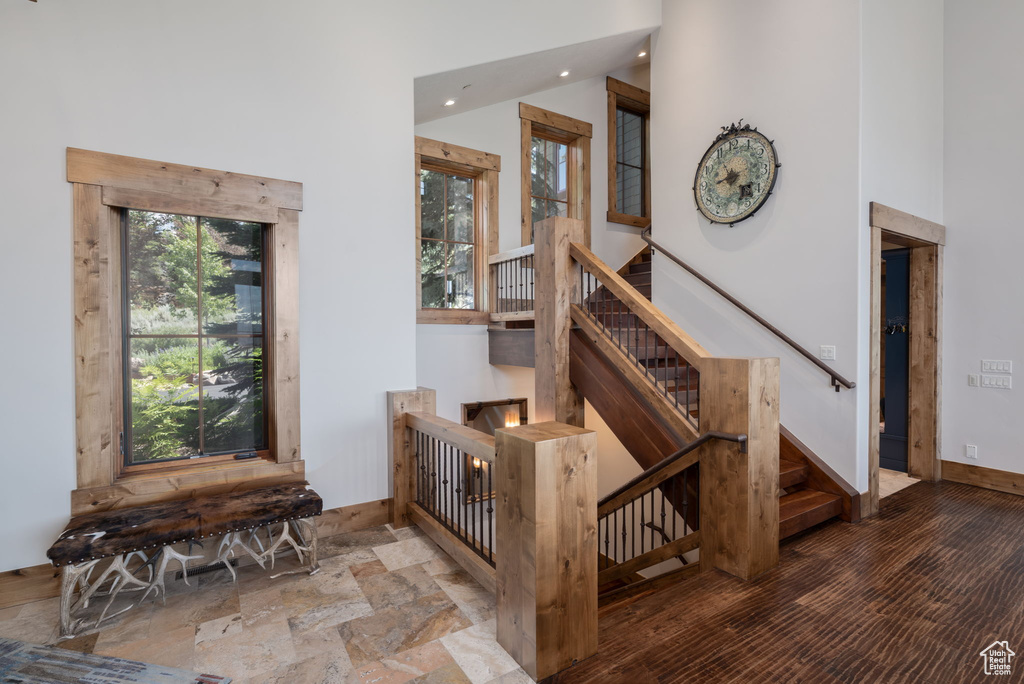 Staircase featuring recessed lighting and a high ceiling