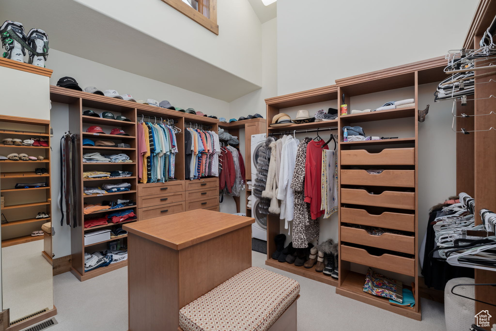Spacious closet with light colored carpet and a high ceiling