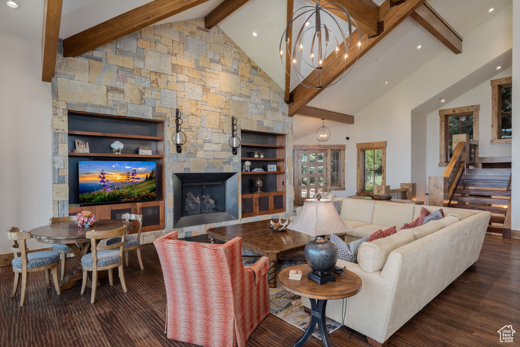 Living room featuring beam ceiling, high vaulted ceiling, recessed lighting, wood finished floors, and a stone fireplace