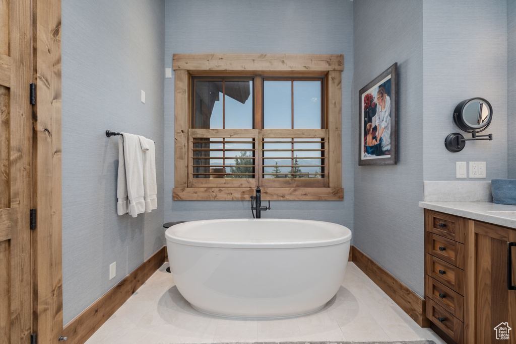 Full bath featuring vanity, a freestanding tub, and wood finished floors