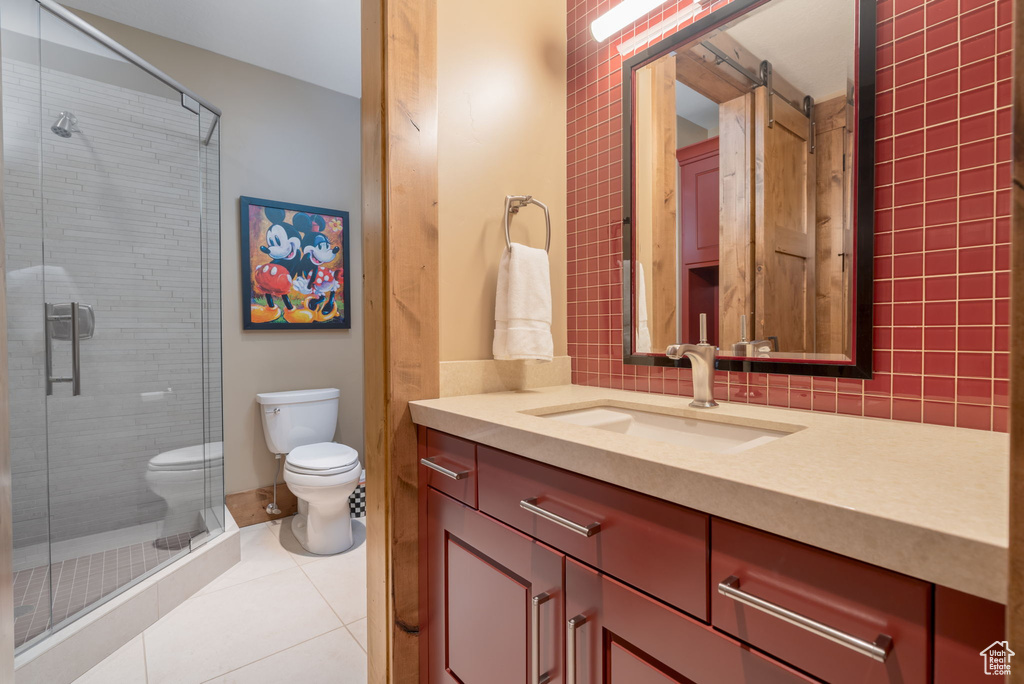 Bathroom with tile patterned flooring, vanity, a shower stall, and decorative backsplash