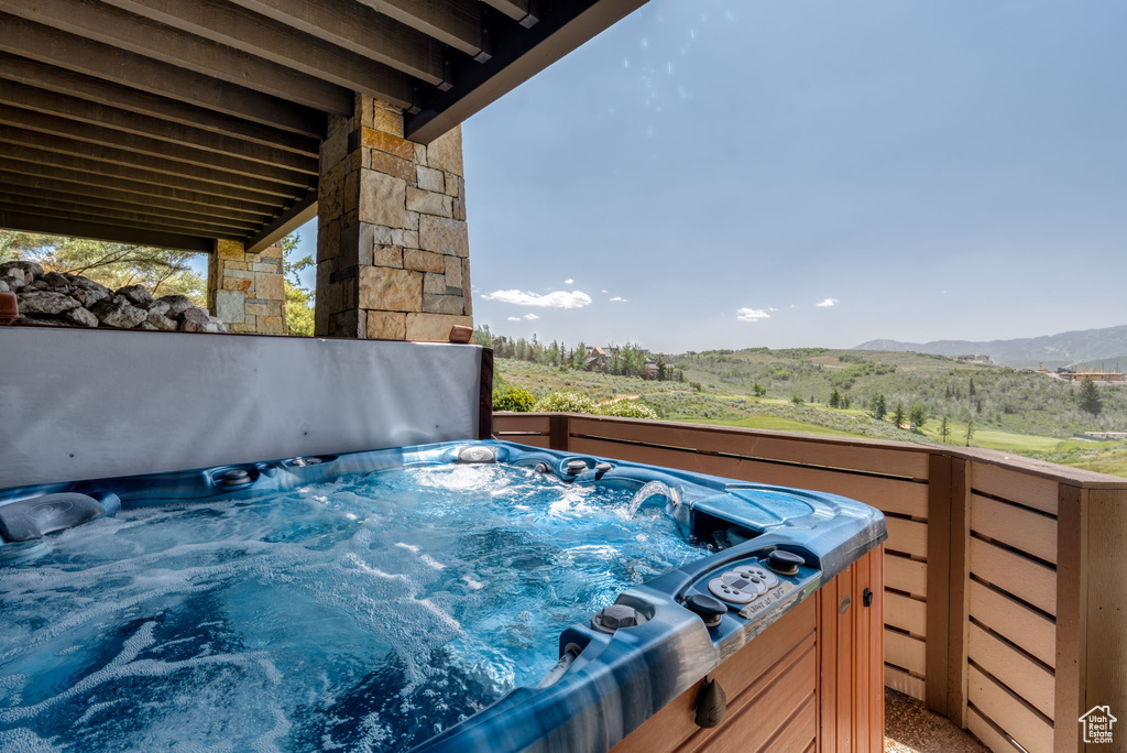 View of patio featuring a hot tub and a mountain view