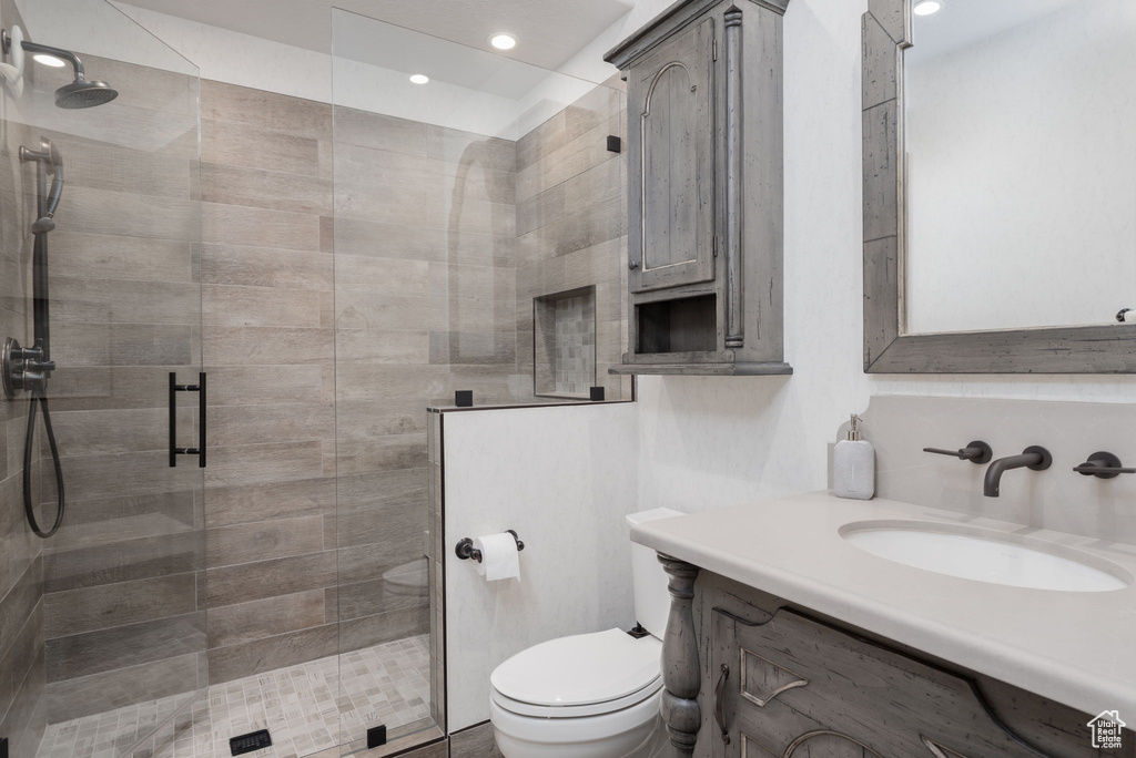 Full bath with a stall shower, vanity, and recessed lighting