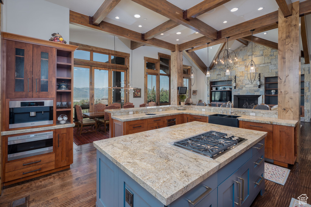 Kitchen with stainless steel gas cooktop, a large island, dark wood-style flooring, open floor plan, and recessed lighting