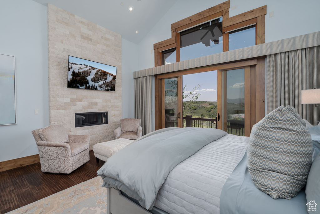 Bedroom featuring access to outside, wood finished floors, high vaulted ceiling, a fireplace, and recessed lighting