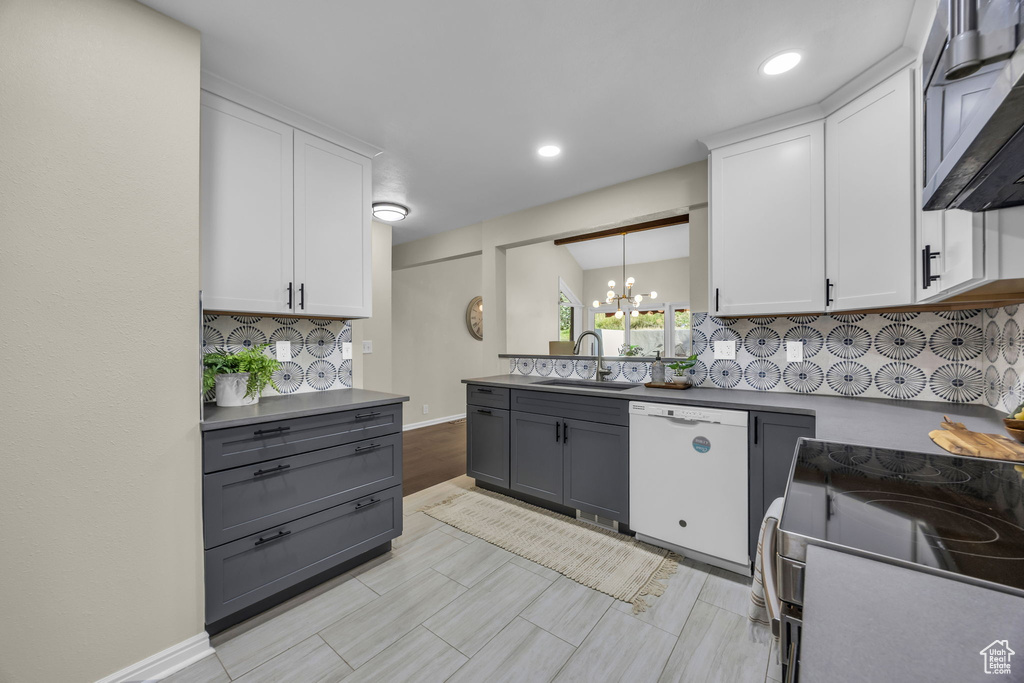 Kitchen featuring white dishwasher, gray cabinetry, range with electric cooktop, a chandelier, and white cabinets