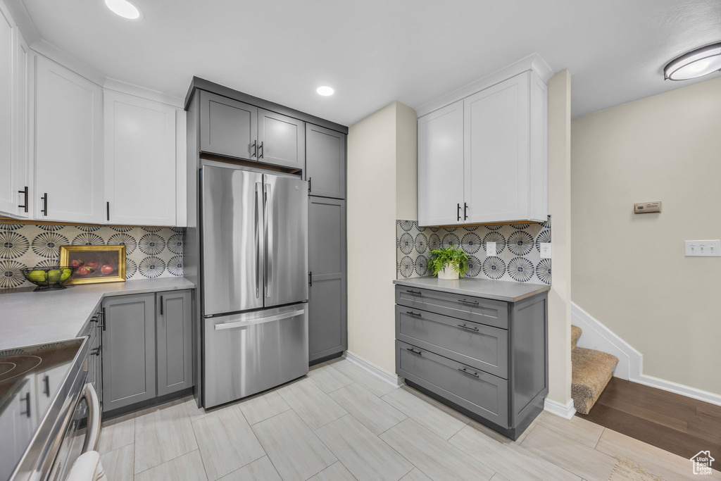 Kitchen featuring appliances with stainless steel finishes, gray cabinetry, backsplash, recessed lighting, and light countertops