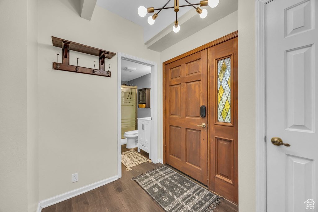 Foyer entrance featuring a chandelier and dark wood-type flooring