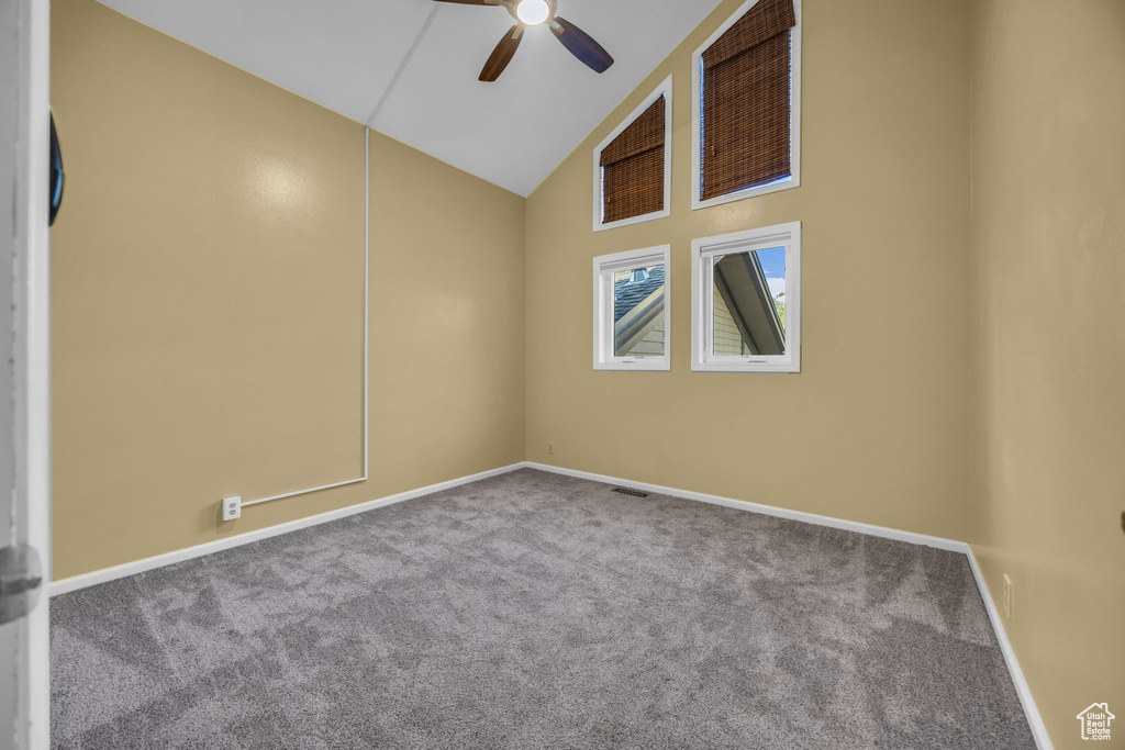 Unfurnished room featuring carpet flooring, a ceiling fan, and high vaulted ceiling