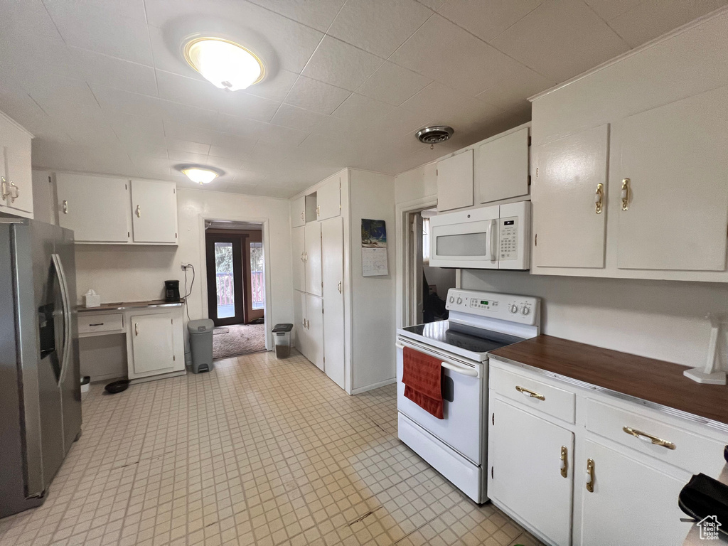 Kitchen featuring white appliances and white cabinets