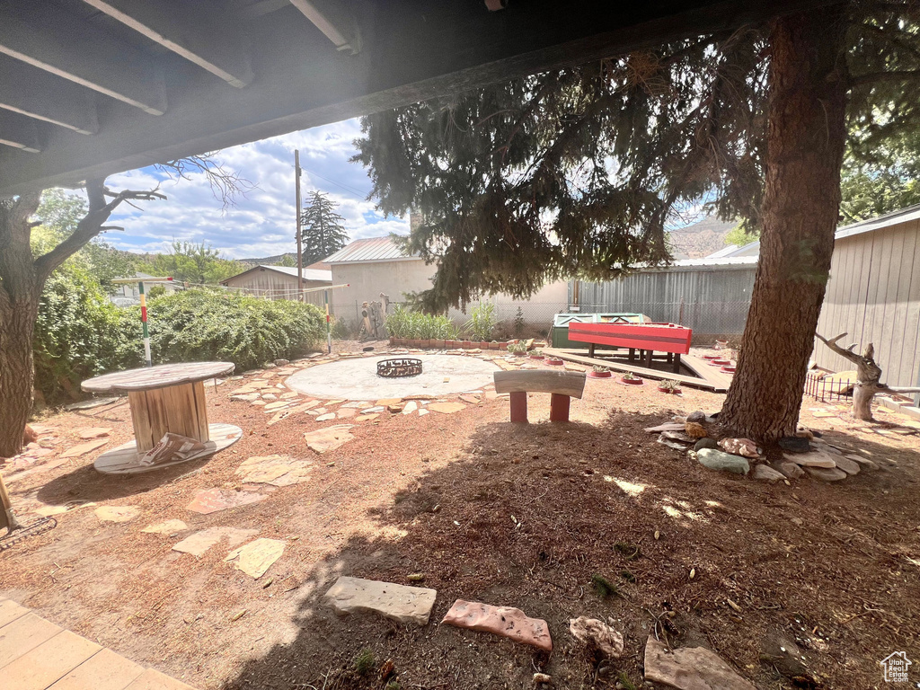 Fenced backyard featuring an outdoor fire pit and a patio area