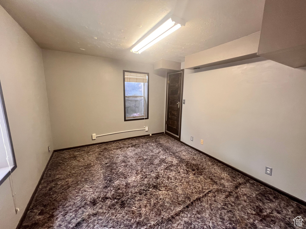 Empty room with carpet and baseboard heating