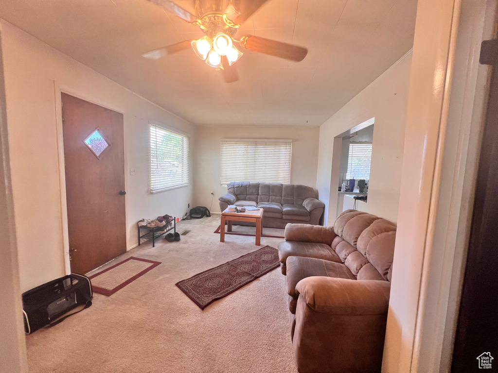 Carpeted living room featuring a ceiling fan