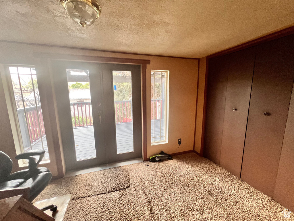 Entryway with carpet and a textured ceiling