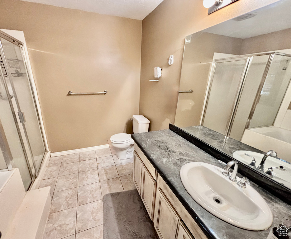 Full bathroom with a shower stall, vanity, and tile patterned flooring
