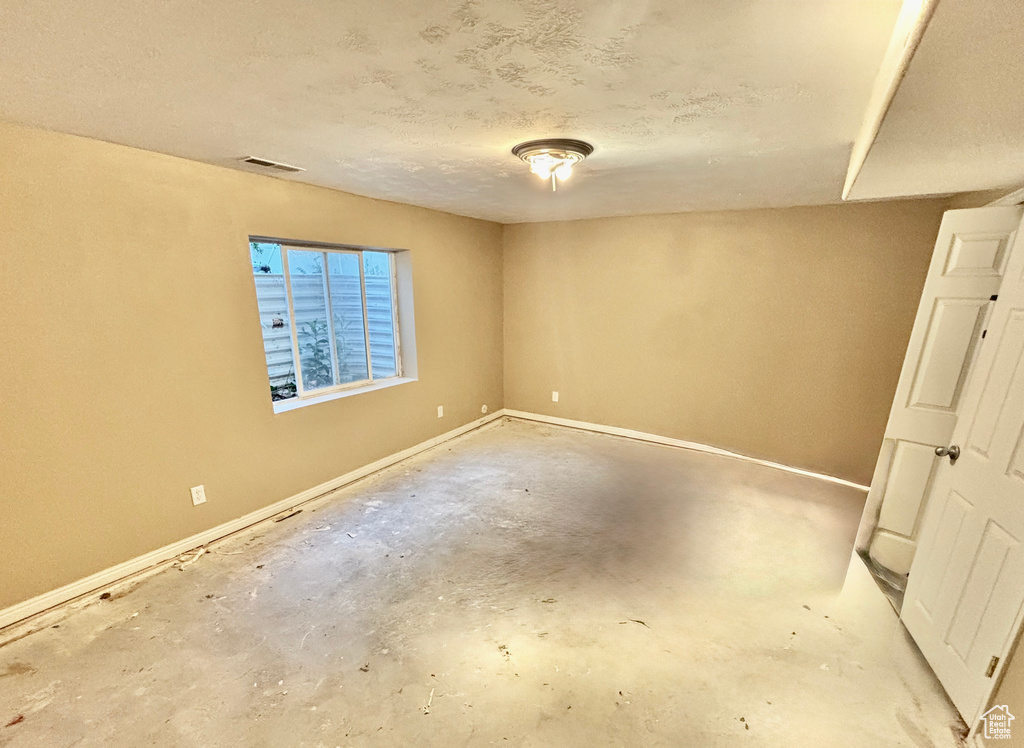 Empty room with concrete floors and a textured ceiling