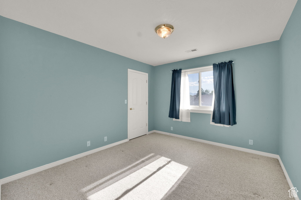 Carpeted spare room with baseboards