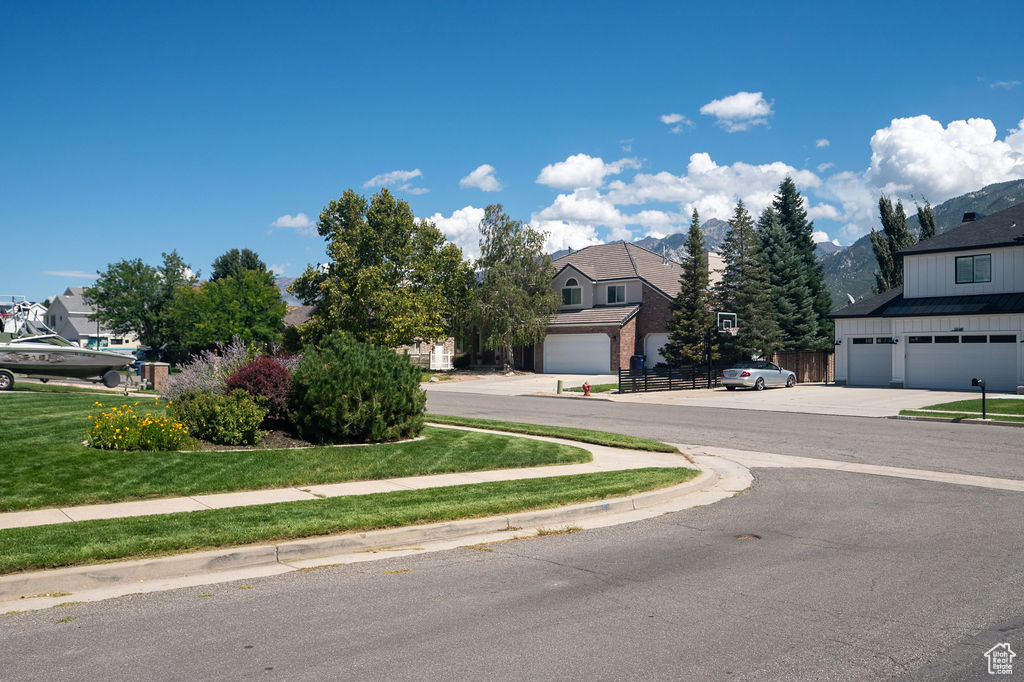 View of asphalt street with a residential view, sidewalks, and curbs