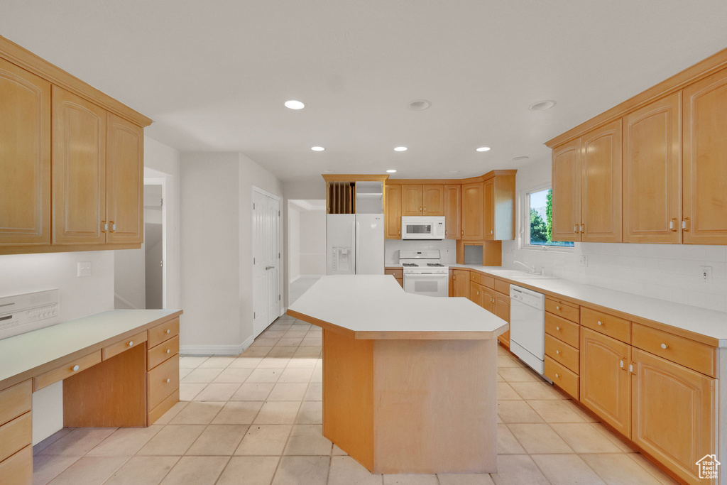 Kitchen with white appliances, recessed lighting, light countertops, a kitchen island, and light tile patterned floors