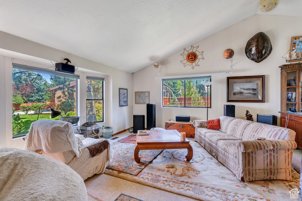 Living area featuring vaulted ceiling and light colored carpet