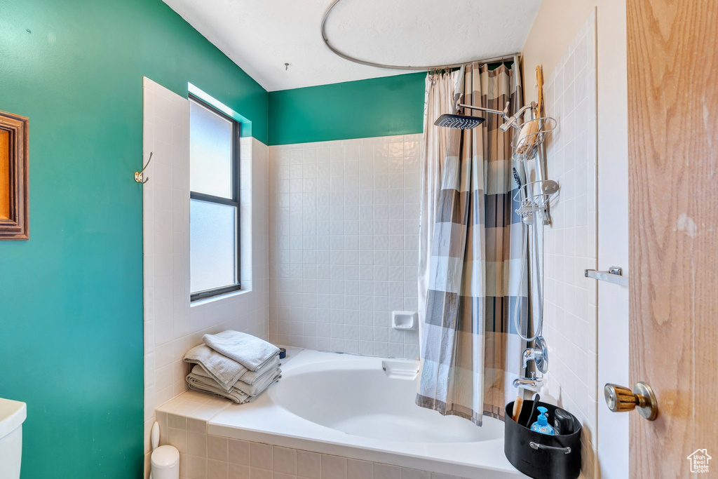 Full bath featuring plenty of natural light and tiled shower / bath combo