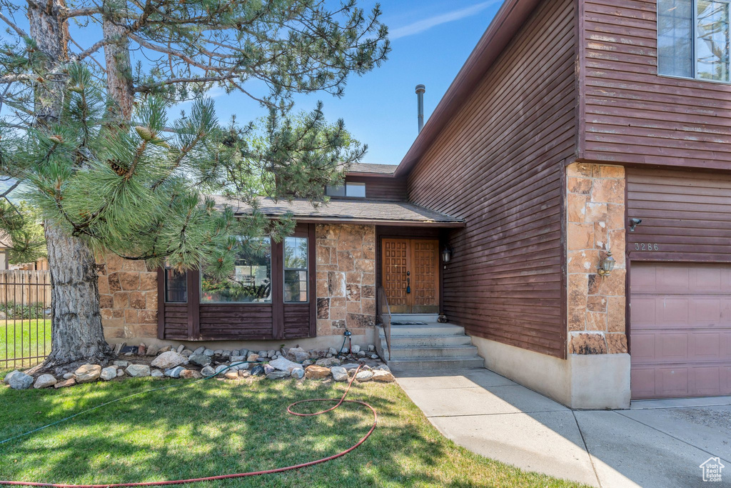 View of front of house featuring stone siding and an attached garage