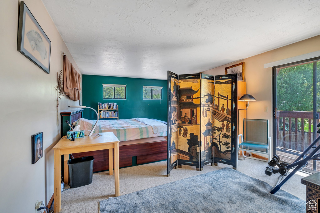 Bedroom featuring access to outside, carpet, and a textured ceiling