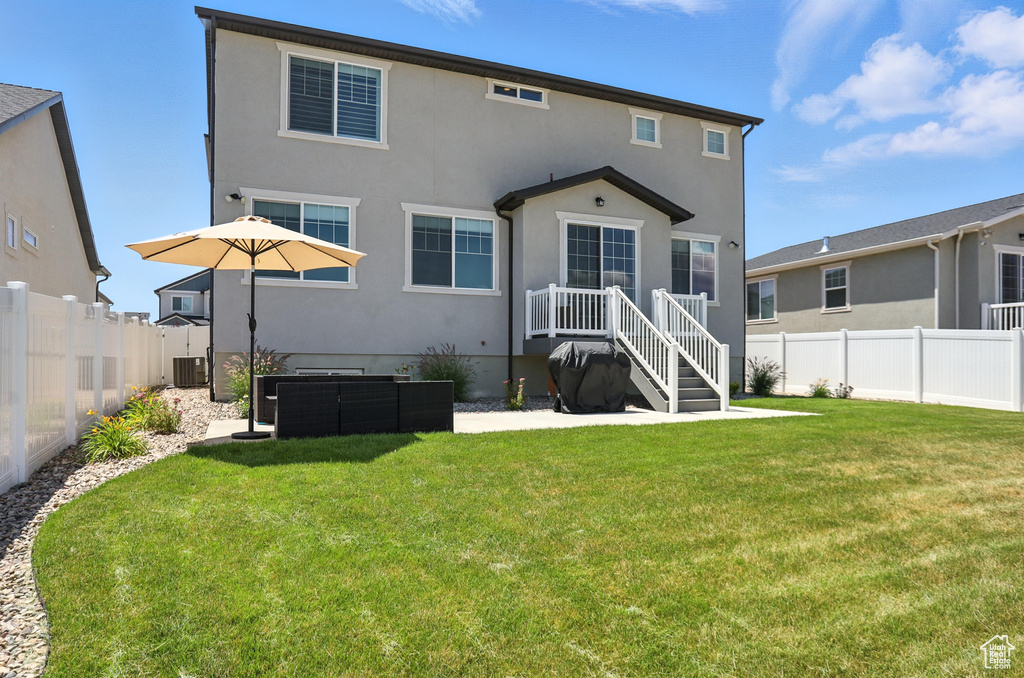 Rear view of house with a fenced backyard and stucco siding