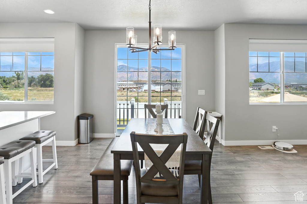 Dining room featuring a chandelier, wood finished floors, recessed lighting, and a mountain view