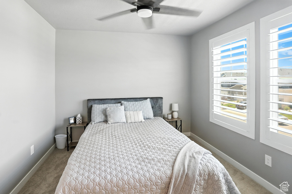 Carpeted bedroom with baseboards and ceiling fan