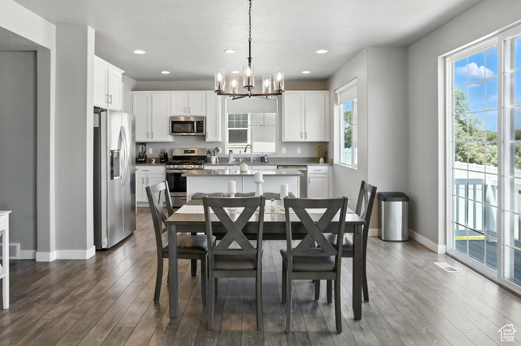 Dining room featuring a chandelier, dark wood-type flooring, and recessed lighting