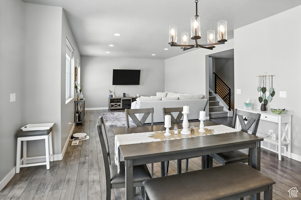 Dining area featuring a chandelier, stairway, hardwood / wood-style floors, and recessed lighting