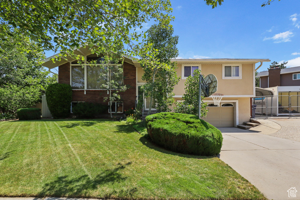 View of front of property with an attached garage, stucco siding, and concrete driveway