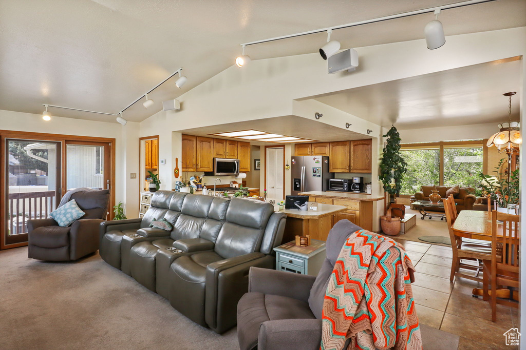 Living room featuring track lighting, lofted ceiling, and light tile patterned floors