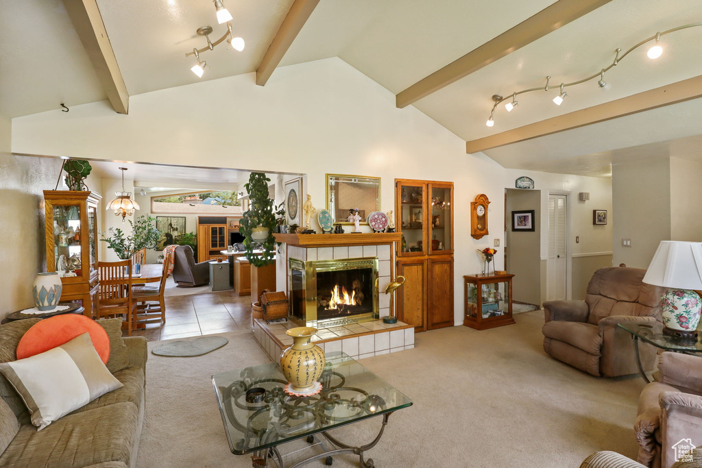 Living room with beamed ceiling, light carpet, a tile fireplace, and high vaulted ceiling