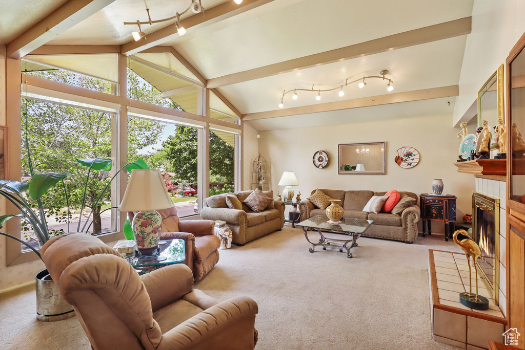 Carpeted living area featuring vaulted ceiling and a tile fireplace