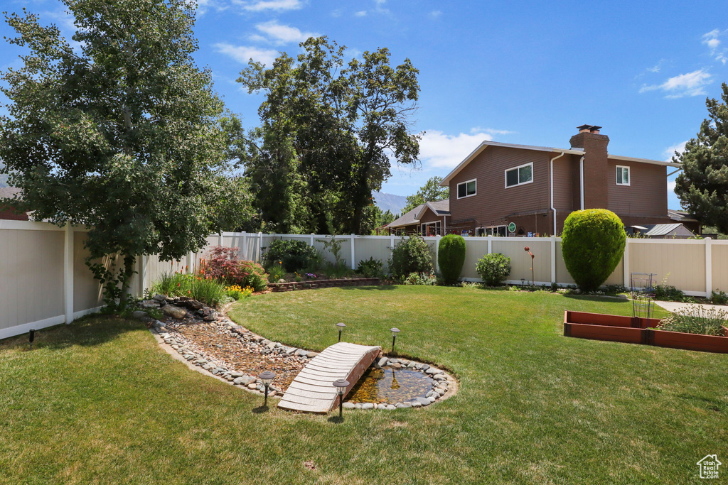 Fenced backyard featuring a garden