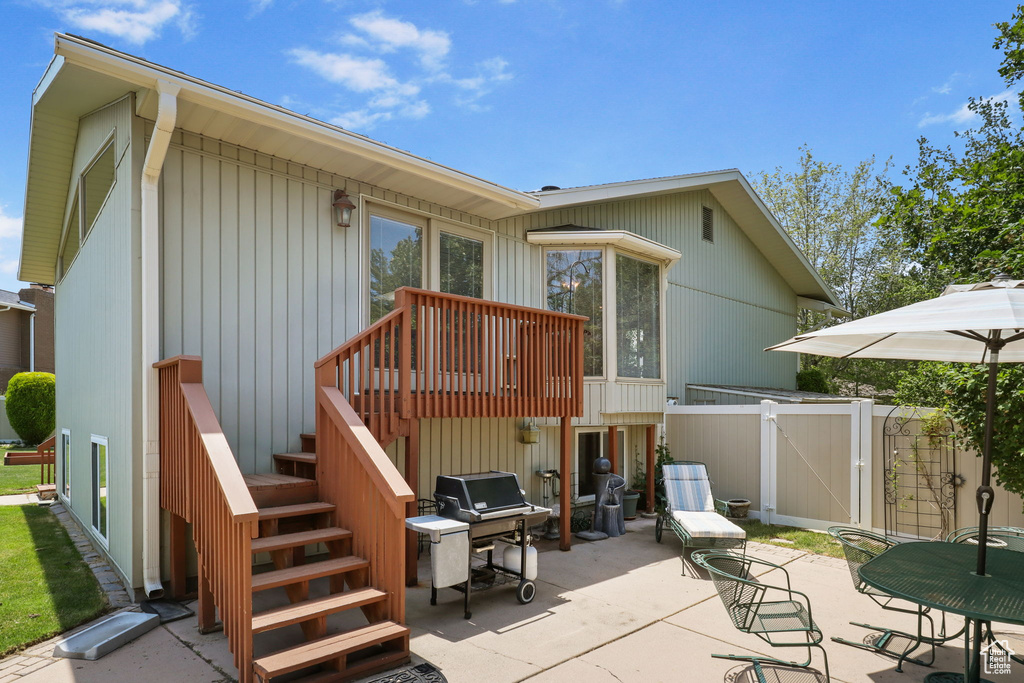 Rear view of property with a gate, stairs, and a patio area