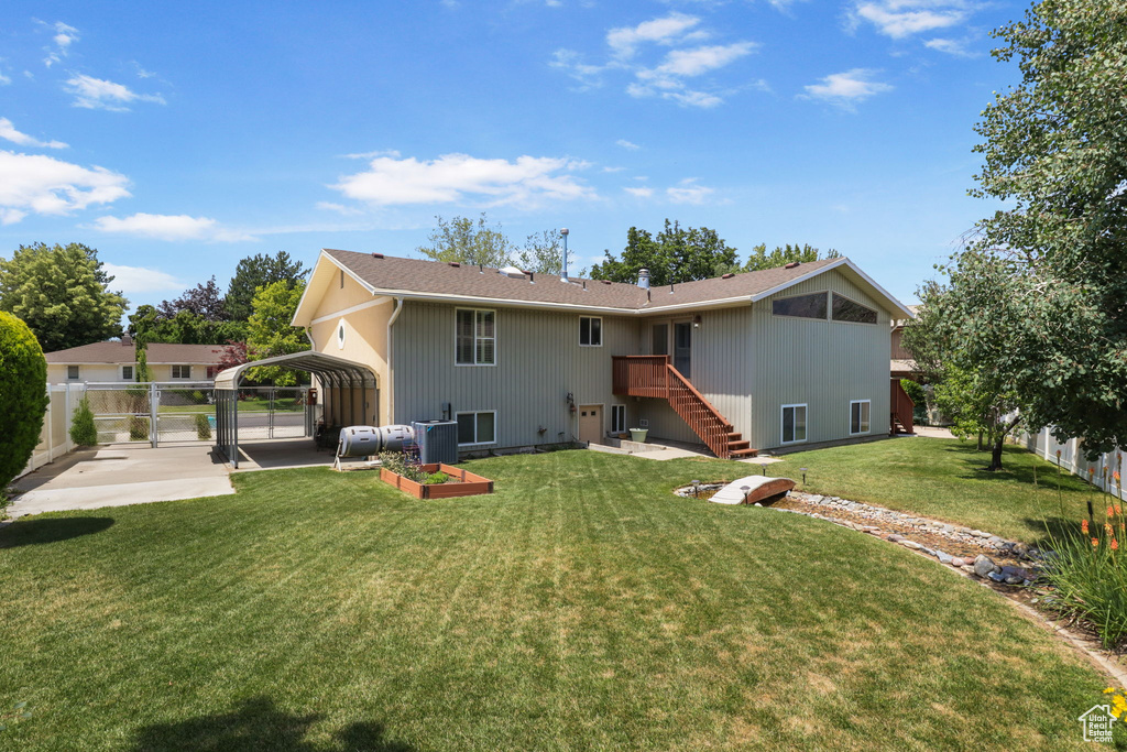 Rear view of house with a detached carport, stairway, and a gate