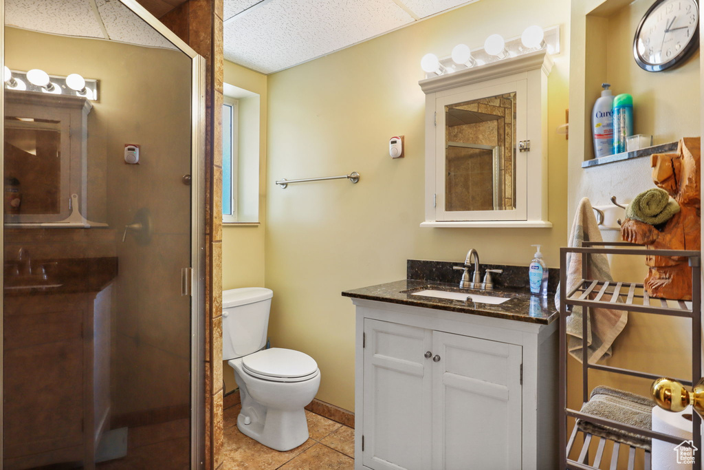Full bathroom featuring vanity, a stall shower, tile patterned flooring, and a paneled ceiling