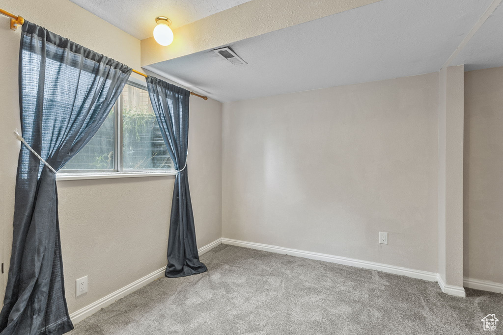 Carpeted empty room with baseboards