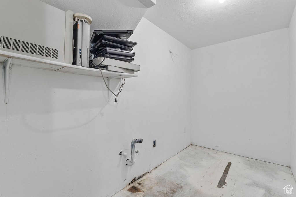Laundry area featuring a textured ceiling