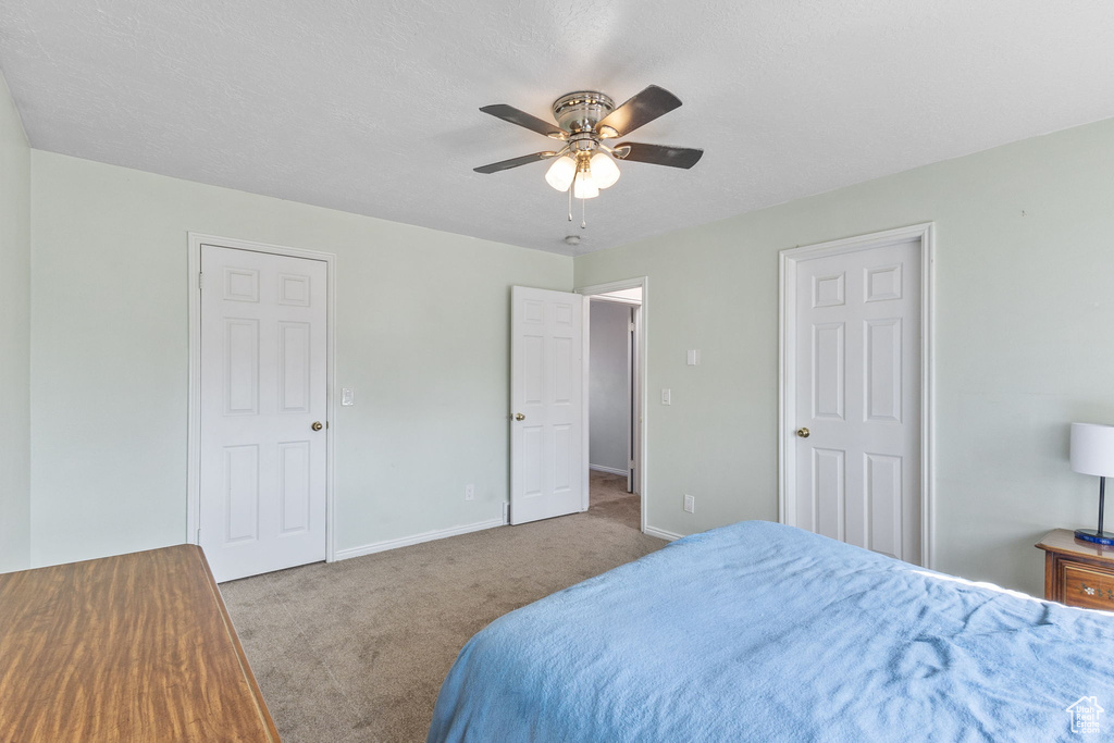 Carpeted bedroom with baseboards and a ceiling fan