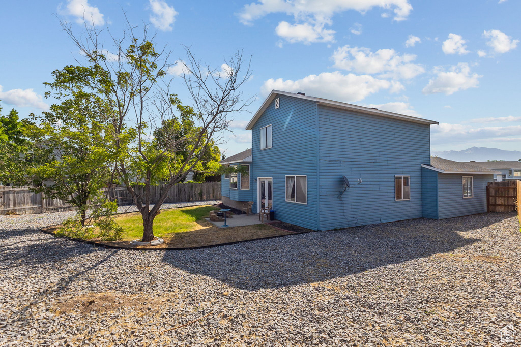 Rear view of property with a fenced backyard and a patio area