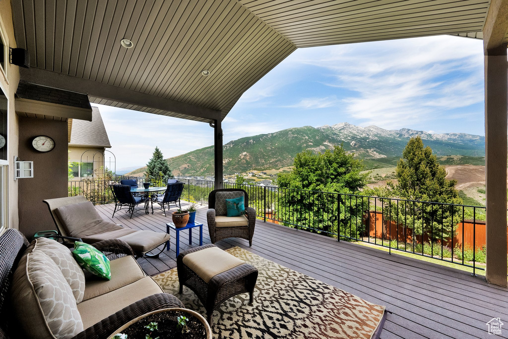 Wooden terrace featuring a mountain view, outdoor dining space, and an outdoor living space