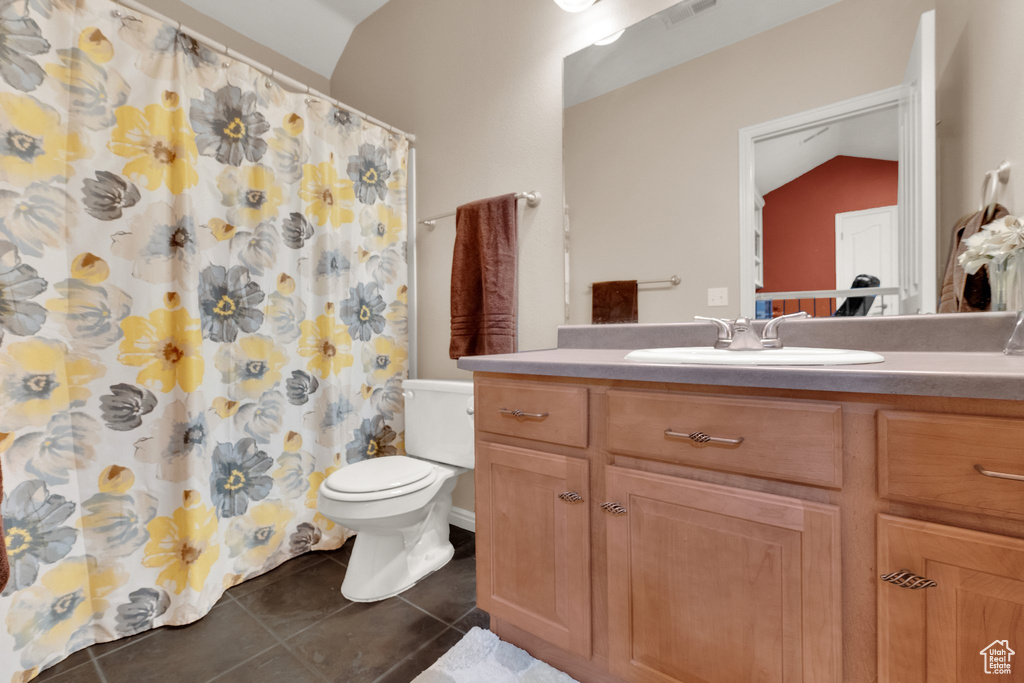 Full bath with vaulted ceiling, vanity, tile patterned floors, and curtained shower
