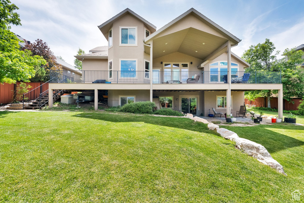 Back of property featuring stucco siding, a patio, stairway, and a wooden deck