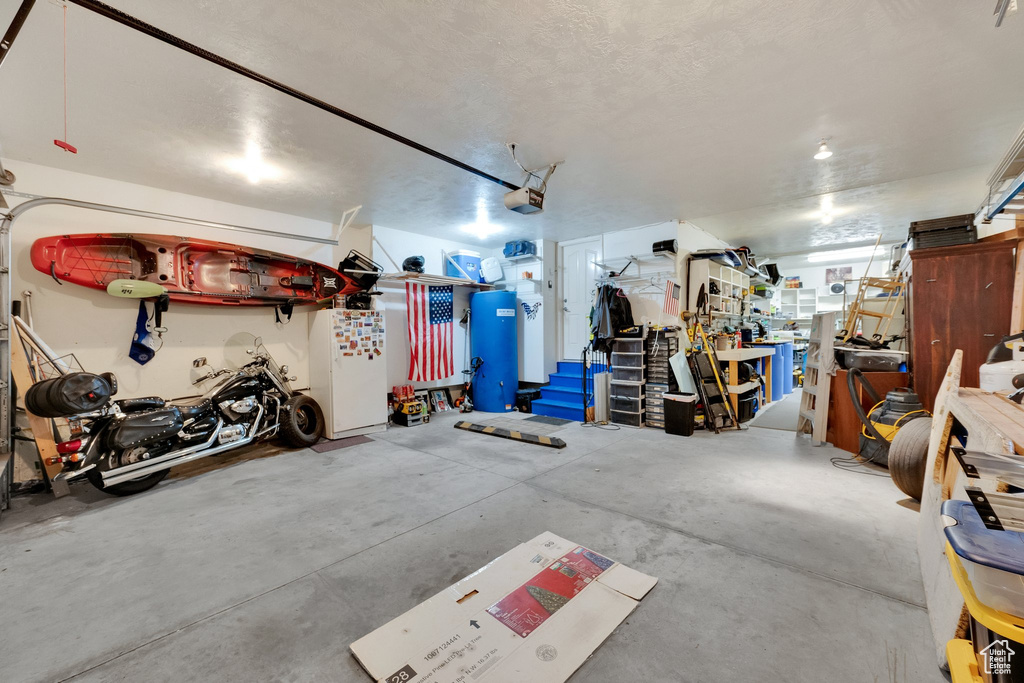 Garage featuring a garage door opener and a workshop area