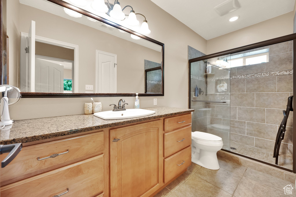Bathroom with vanity, a stall shower, and tile patterned flooring